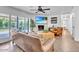 Cozy living room features a fireplace, ceiling fan, and abundant natural light from the large windows at 3505 N Miller Rd, Scottsdale, AZ 85251