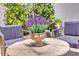 Cozy outdoor seating area with a wooden table, chairs, and potted flowers, perfect for relaxation at 3505 N Miller Rd, Scottsdale, AZ 85251