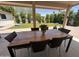 Covered outdoor patio with dining table, lush artificial grass, and views of the backyard at 3505 N Miller Rd, Scottsdale, AZ 85251