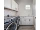 Functional laundry room with washer, dryer, white cabinets, and a sink area at 3710 E Cheery Lynn Rd, Phoenix, AZ 85018