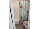 A bathroom with a toilet with a wood seat and a patterned curtain at 3825 E Camelback Rd # 152, Phoenix, AZ 85018