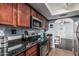 Well-equipped kitchen with stainless steel appliances, dark granite countertops and wood cabinets at 3825 E Camelback Rd # 152, Phoenix, AZ 85018
