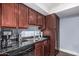 Close up view of kitchen with stainless steel appliances, dark granite countertops, and wood cabinets at 3825 E Camelback Rd # 152, Phoenix, AZ 85018