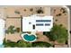 An aerial view of a property featuring a pool, desert landscape, and rooftop solar panels at 4032 E Cannon Dr, Phoenix, AZ 85028