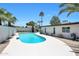 A backyard pool is surrounded by palm trees and desert landscaping, with clear blue water on a sunny day at 4079 E Yucca St, Phoenix, AZ 85028