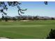 View of golf course with lush green fairways, mature trees and mountain views in the distance at 4239 E Azalea Dr, Gilbert, AZ 85298