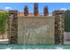 Detailed view of the decorative pool waterfall featuring natural stone and potted plants at 4239 E Azalea Dr, Gilbert, AZ 85298
