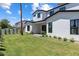 Expansive backyard with lush lawn, manicured landscaping, and a modern white home at 4301 E Sells Dr, Phoenix, AZ 85018