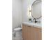 Stylish powder room with modern vanity, round mirror, and tasteful decor at 4301 E Sells Dr, Phoenix, AZ 85018