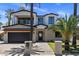 Stunning two-story home featuring a brick exterior, black accents, and lush palm tree landscaping at 4301 E Sells Dr, Phoenix, AZ 85018