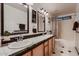 Bright bathroom offers double sinks, a tub and shower combination, and black and white decor at 4437 E Dartmouth St, Mesa, AZ 85205