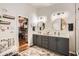 Stylish bathroom with dual sinks, modern lighting, decorative mirrors, and access to the walk-in closet at 4437 E Dartmouth St, Mesa, AZ 85205