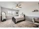 Well-lit bedroom with neutral tones, ceiling fan, a comfortable bed, and a desk area for work or study at 4437 E Dartmouth St, Mesa, AZ 85205