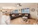 Cozy living room area with a large sectional sofa, tile flooring, ceiling fan, and view of the kitchen at 4437 E Dartmouth St, Mesa, AZ 85205