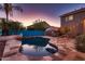 Sparkling pool at dusk, surrounded by lush landscaping, a patio, and a barbecue area at 4437 E Dartmouth St, Mesa, AZ 85205