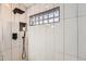 Modern walk-in shower featuring white tile, a rainfall shower head, and a convenient built-in niche at 4437 E Dartmouth St, Mesa, AZ 85205