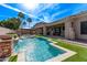 Resort-style backyard boasts a sparkling pool, turf, and a covered patio perfect for entertaining at 4667 E Reins Rd, Gilbert, AZ 85297