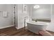 Elegant bathroom features a freestanding tub beneath a window and decorative wall paneling at 4667 E Reins Rd, Gilbert, AZ 85297