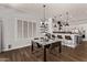 Bright dining area with glass table and adjacent kitchen, featuring contemporary lighting and shutters at 4667 E Reins Rd, Gilbert, AZ 85297