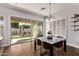 Light-filled dining area with glass table, modern chandelier, and outdoor patio access at 4667 E Reins Rd, Gilbert, AZ 85297