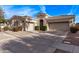 Spacious driveway leads to a well-kept home with archway gate, a two-car garage and landscaping at 4667 E Reins Rd, Gilbert, AZ 85297