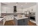 Modern kitchen featuring white cabinets, gray backsplash, stainless steel appliances, and a center island at 4667 E Reins Rd, Gilbert, AZ 85297