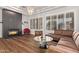 Stylish living room featuring a modern fireplace, plantation shutters, wood floors, and elegant chandelier at 4667 E Reins Rd, Gilbert, AZ 85297