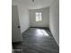 Bedroom featuring modern flooring, brick accent wall, and window letting in natural light at 4916 W Earll Dr, Phoenix, AZ 85031