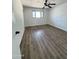 Bedroom featuring wood-look flooring, white brick walls, window, and a ceiling fan at 4916 W Earll Dr, Phoenix, AZ 85031