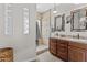 Well-lit bathroom featuring a double sink vanity, step-in shower, and earth-tone accents at 5303 W Hackamore Dr, Phoenix, AZ 85083