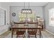 Comfortable dining room with a wood table, chairs and a modern chandelier lighting fixture at 5303 W Hackamore Dr, Phoenix, AZ 85083
