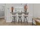 Eat-in kitchen bar with three comfortable stools, sleek countertops, and seamless flow into the main kitchen at 5303 W Hackamore Dr, Phoenix, AZ 85083