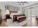 Spacious main bedroom with a wood bed frame, wood floors, ceiling fan, and private access to the backyard at 5303 W Hackamore Dr, Phoenix, AZ 85083