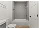 Bathroom featuring a white bathtub, shower with gray tiled surround, and toilet at 5808 W Myrtle Ave, Glendale, AZ 85301