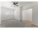 Bright bedroom with a ceiling fan, carpet, window and door to next room at 5808 W Myrtle Ave, Glendale, AZ 85301