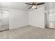 Bright and airy carpeted bedroom with white walls, a ceiling fan, and an open doorway at 5808 W Myrtle Ave, Glendale, AZ 85301