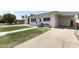 Charming white home featuring a well-kept lawn, walkway, covered parking, and decorative front door at 5808 W Myrtle Ave, Glendale, AZ 85301