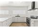 Modern kitchen with white cabinets, countertops, black hardware, and stainless steel appliances at 5808 W Myrtle Ave, Glendale, AZ 85301
