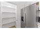 Stainless steel refrigerator next to a pantry with lots of storage shelves at 5808 W Myrtle Ave, Glendale, AZ 85301