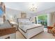 Bright bedroom with a balcony, elegant chandelier, and stylish neutral decor at 5905 N Echo Canyon Ln, Phoenix, AZ 85018