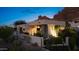 Stylish home with modern design, desert landscaping, and illuminated features, nestled against a stunning mountain backdrop at 5905 N Echo Canyon Ln, Phoenix, AZ 85018