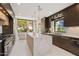 Modern kitchen featuring a large island, sleek dark cabinets, and stainless steel appliances at 5905 N Echo Canyon Ln, Phoenix, AZ 85018