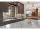 Elegant kitchen showcasing dark cabinetry, gold hardware, and a large marble island at 5905 N Echo Canyon Ln, Phoenix, AZ 85018