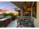 Outdoor dining area with built-in grill, glass table and chairs, sunset view, and lush landscaping at 5905 N Echo Canyon Ln, Phoenix, AZ 85018