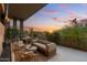 Beautiful outdoor patio featuring stylish wicker furniture, lush landscaping, and stunning sunset mountain views at 5905 N Echo Canyon Ln, Phoenix, AZ 85018