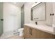 Well-lit bathroom with a modern vanity, sleek mirror, and glass-enclosed shower at 6126 E Charter Oak Rd, Scottsdale, AZ 85254