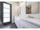 Modern bathroom features double sinks, white cabinets, marble countertop, and a large mirror at 6126 E Charter Oak Rd, Scottsdale, AZ 85254