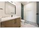 Well-lit bathroom with a modern vanity, sleek mirror, and glass-enclosed shower at 6126 E Charter Oak Rd, Scottsdale, AZ 85254
