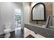 Contemporary powder bathroom featuring stylish vanity with arch mirror and tiled accent wall at 6126 E Charter Oak Rd, Scottsdale, AZ 85254