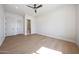 Bright bedroom with a ceiling fan, light hardwood floors and easy bathroom access at 6126 E Charter Oak Rd, Scottsdale, AZ 85254